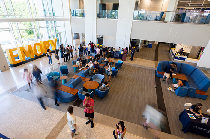 aerial view of interior of open space with comfortable chairs and many people sitting, standing, and passing through